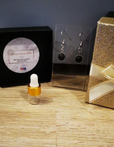 boucle d'oreille sphère en acier inoxydale argenté et une perle de lave noire
