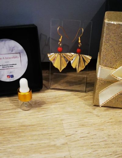 boucle d'oreille triangle ondulé en acier inoxydale doré et une perle de lave rouge