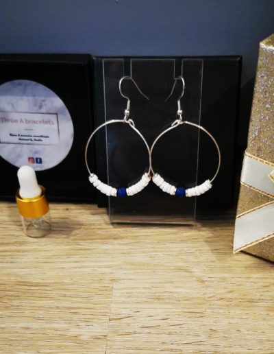 boucles d'oreilles créoles en acier inoxydale argenté et perles de coquillage et une perle de lave bleu foncé