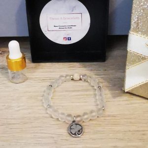 bracelet élastique perles en verre opaque et un trèfle argenté en acier inoxydable