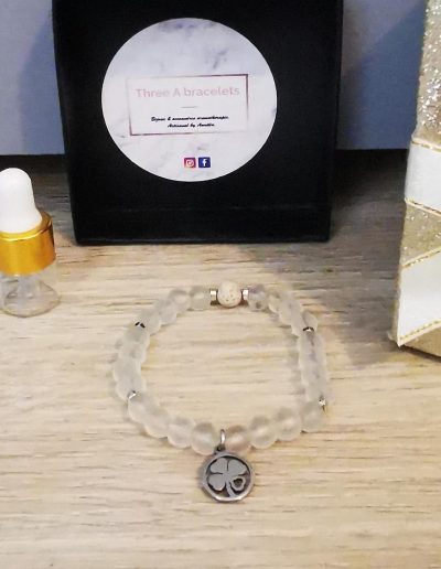 bracelet élastique perles en verre opaque et un trèfle argenté en acier inoxydable