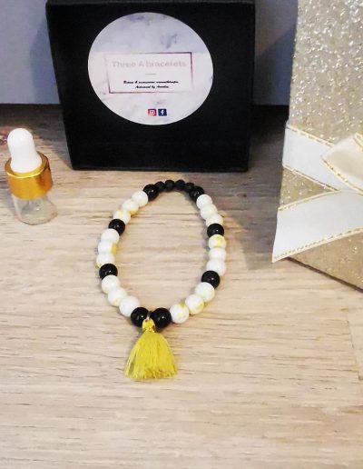 bracelet élastique pompon jaune fluo et perle blanche doré et perles en verre noir brillante