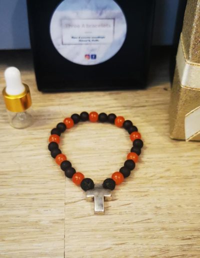 bracelet enfant perles en verre orange, perles en verre noir mâte, une croix argenté en acier inoxydable et une perle de lave noire 6mm