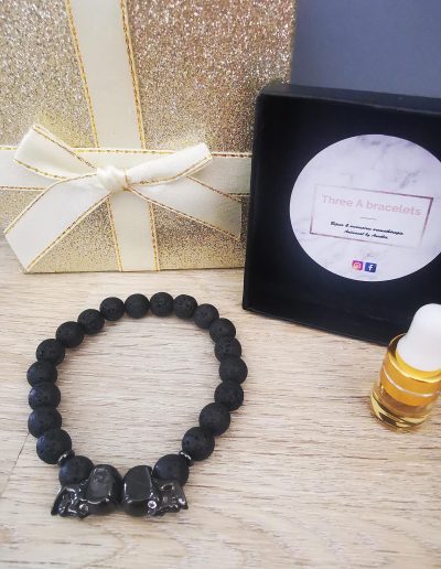 bracelet pierre de lave et 2 tetes de mort noir a strass